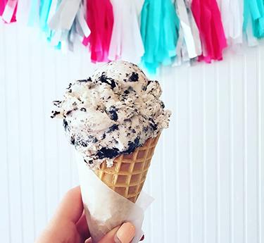 A hand holding an ice cream cone