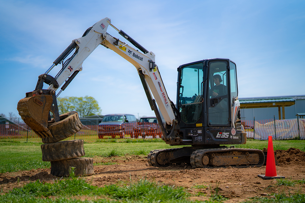A person attempting to stack tires with a Bobcat Backhoe at Hagerstown's Heavy Metal Playground