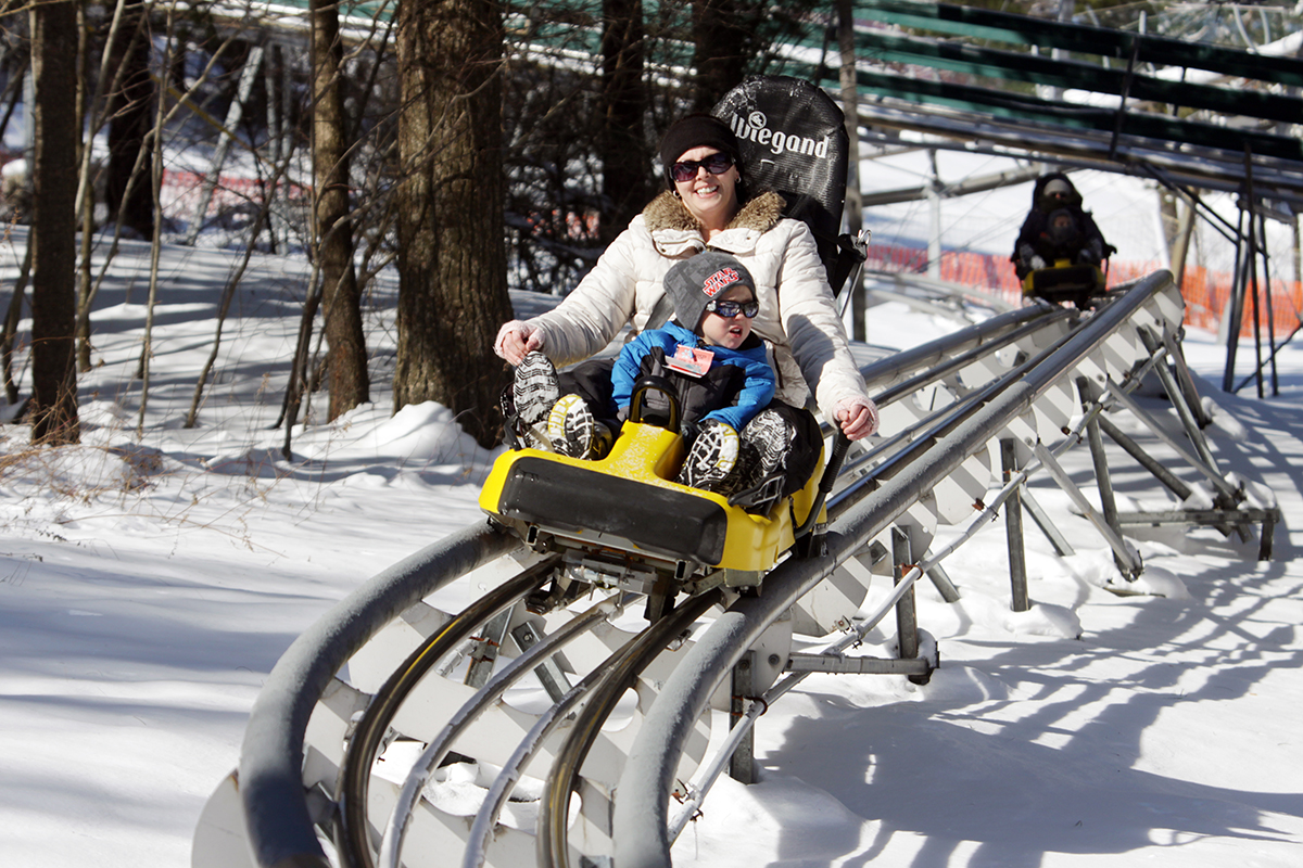 Mom and son riding the rollercoaster in the snow at Wisp