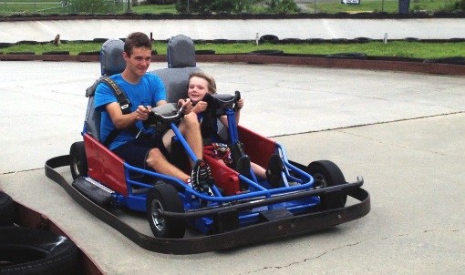 Man and child riding in a go kart