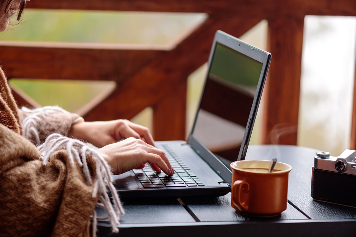 Women working at laptop on porch Photo