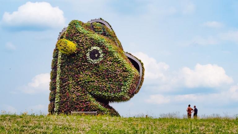 Split Rocker sculpture in full glory on the crest of a clover-covered hill.