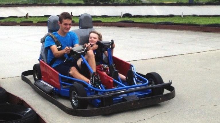 Man and child riding in a go kart