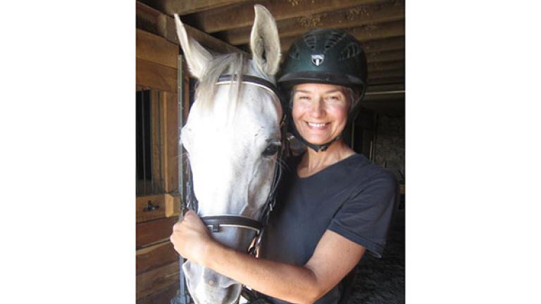 A smiling rider with a horse at New World Stables