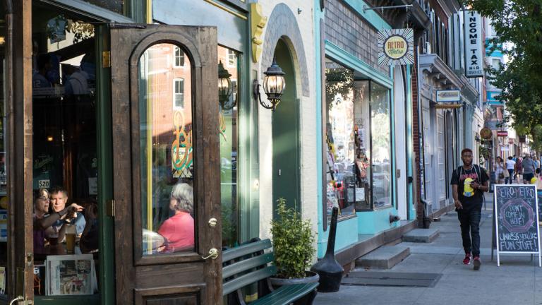 man walking past shops and restaurants in Frederick