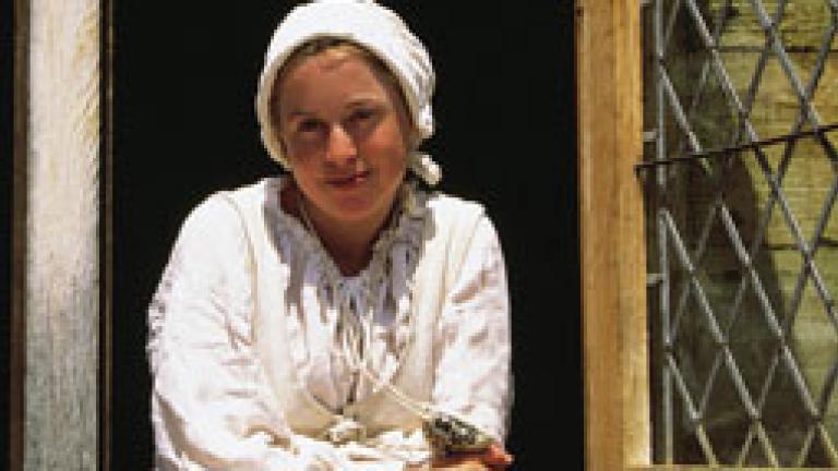 Women in a window dressed in colonial attire