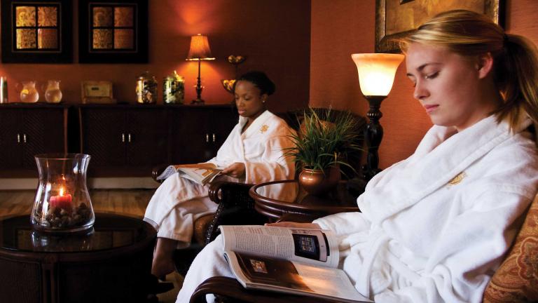 Two women wear white robes at Turf Valley Spa