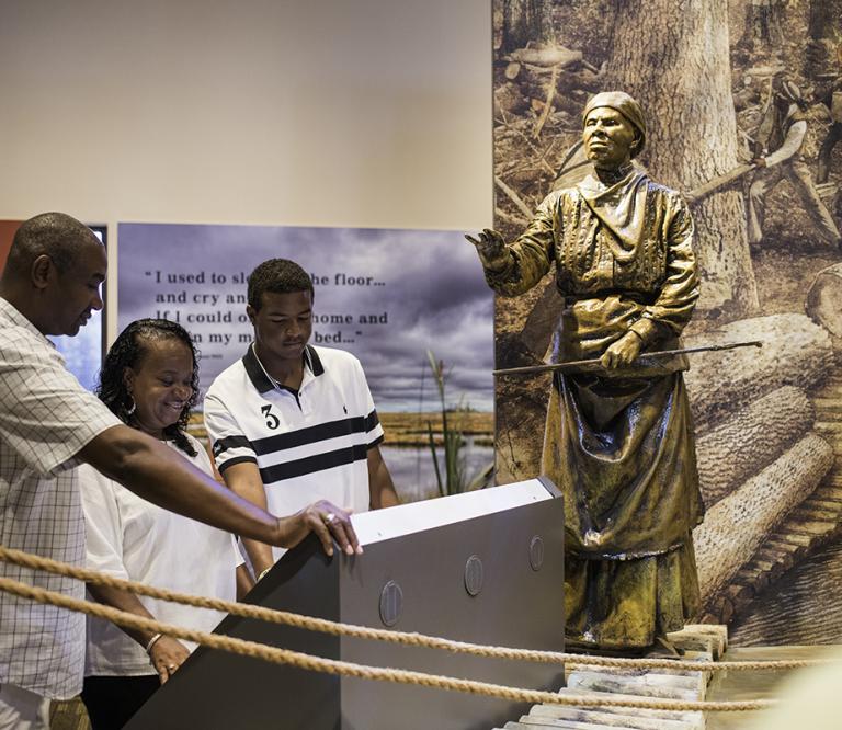 A family reading on a display inside of the Harriet Tubman Underground Railroad visitors Center