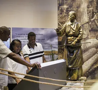 A family reading on a display inside of the Harriet Tubman Underground Railroad visitors Center