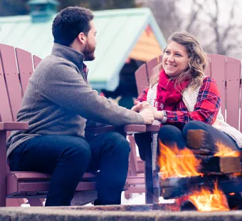 A couple sitting around a cozy fore at the Lake Point Inn in Winter