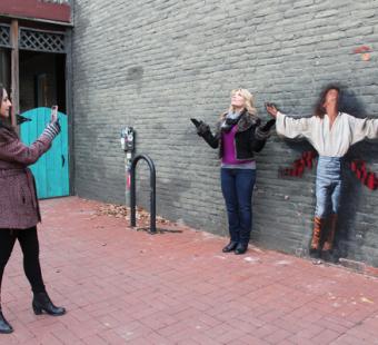 Frederick Visitor Taking Photo Next to Wall Mural