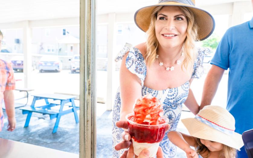 Mother grabbing ice cream from shop