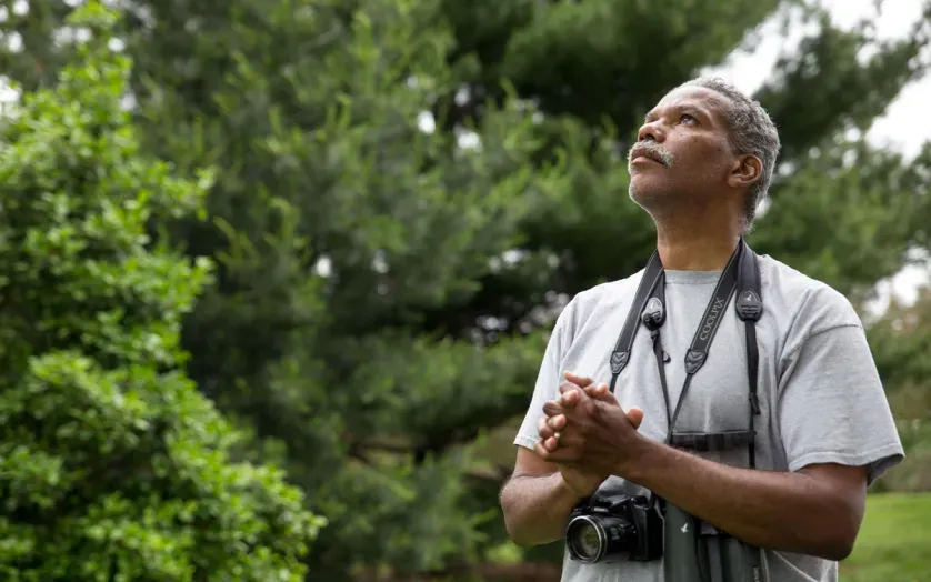 man with binoculars and camera