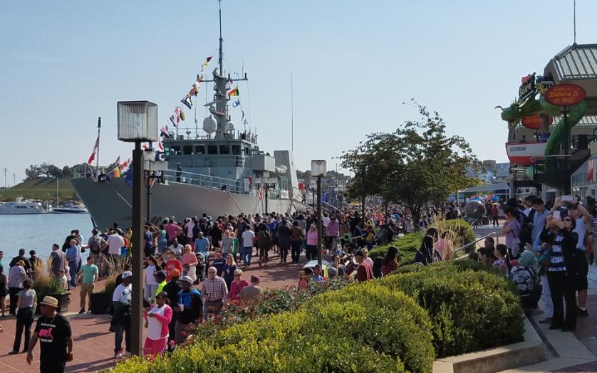 The USS Oak Hill arrives in Baltimore Harbor as crew members stand along the rails