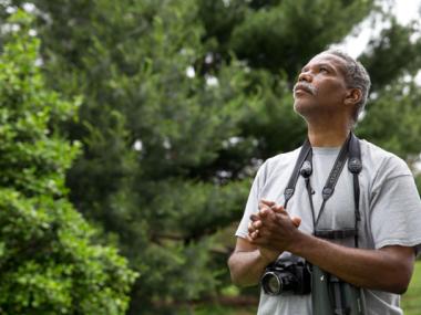man with binoculars and camera
