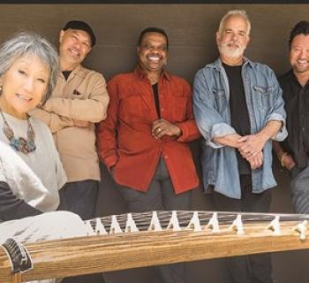 Hiroshima's musicians lean on a wall with the female next to a Japanese instrument Photo