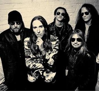 Double Vision musicians gather together against a white brick wall Photo