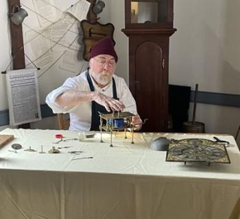 A Clockmaker balancing gears Photo