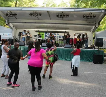 A group of people dancing to music.  Photo