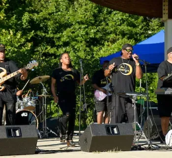 Band performs live during an outdoor concert. Photo