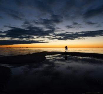 Couple standing near water Photo