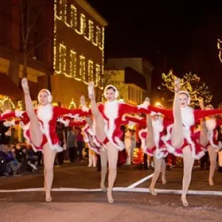 Dancers participating in the procession. The street is twinkling with holiday lights Photo