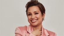 Lea Solanga smiling in a pink blouse. Photo