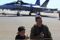 people posing by fighter jet