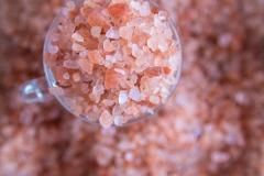 Himilayan Salt Himalayan Salt in a glass sits on top of a field of pink salt