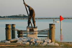 A statue of a waterman hand tonging for oysters
