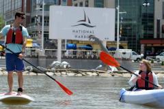 Man on a stand-up paddleboard and a woman in a canoe.
