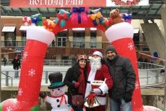 Young man and woman standing with santa claus