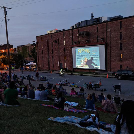 People enjoying an outdoor movie provided by AVAM