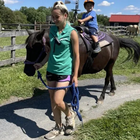 Child being given a pony ride at Clark's Elioak Farm