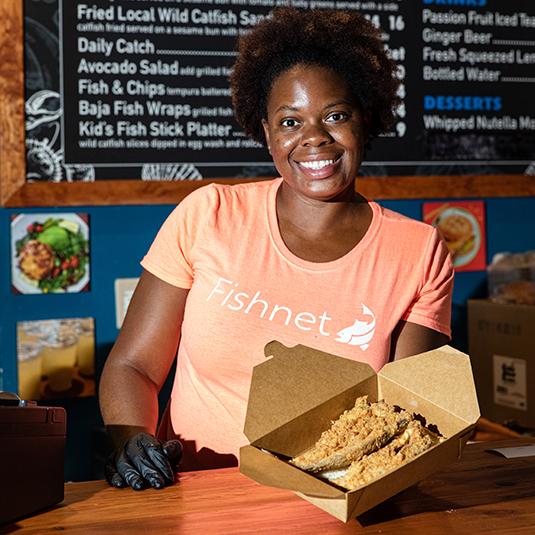 A picture of a female employee from Fishnet showing their food.