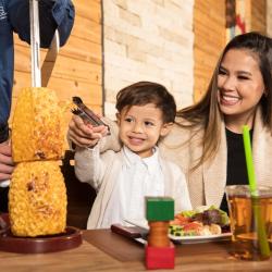 Mother and kids at Rodizio grilled pineapple at the table Photo