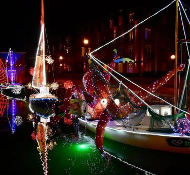 Boats decorated with holiday lights in creek